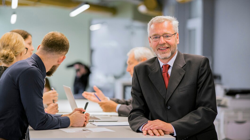 portrait senior businessman front businesspeople discussing office 23 2147923380