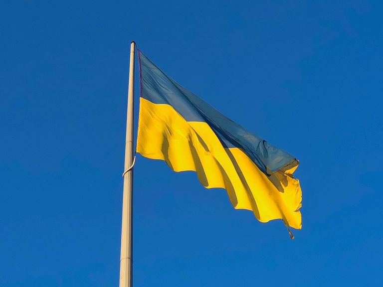 Vibrant Ukrainian flag waving under a clear blue sky, symbolizing national pride.