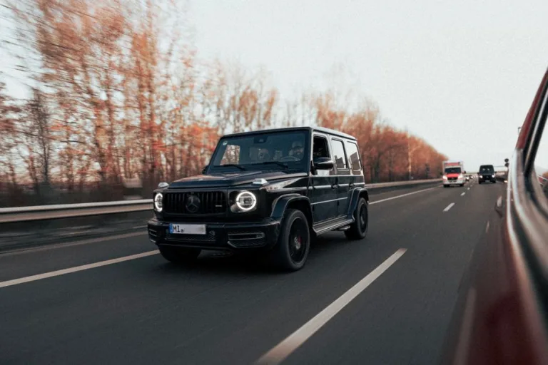 Luxury car interior with plush leather seats, advanced dashboard technology, and spacious cabin during a scenic road trip.