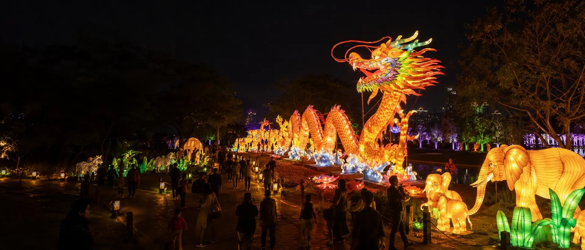 Large illuminated lantern displays forming a colorful night-tourism route in an outdoor visitor attraction
