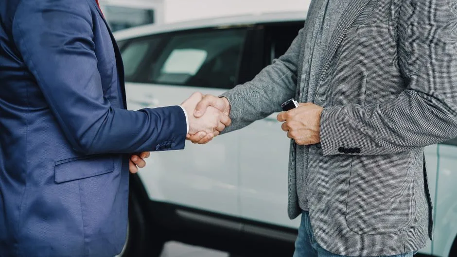 Person reviewing Honda car financing documents and paperwork at dealership before signing agreement